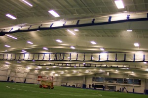 Complete arena construction with ceiling nets, pads, perimeter nets, and three-lift fold curtains at New Hampshire Sportplex.